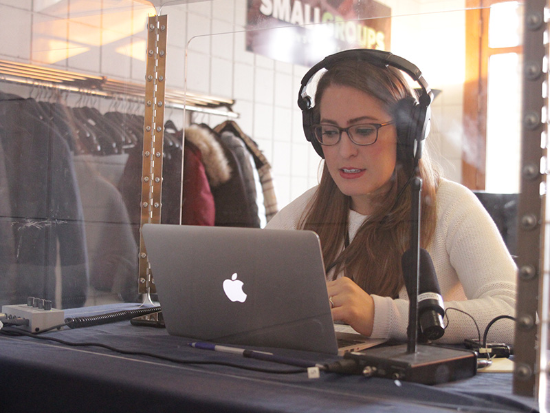 Person sitting at desk wearing headphones to translate service