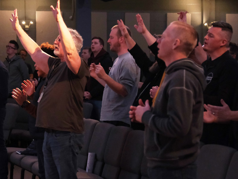Group of men worshiping at church