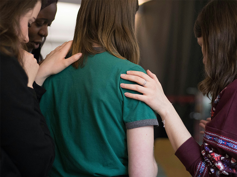 Group of young adults praying together