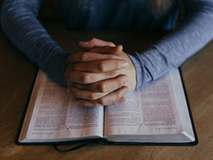 Praying hands over Bible