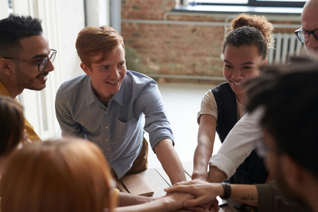 Group of people putting hands on top of each other