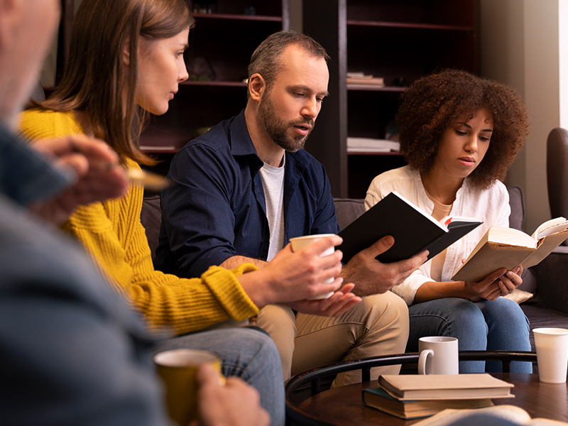 Group of people sitting and reading the Bible together