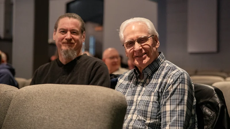 Two men sitting in worship centre