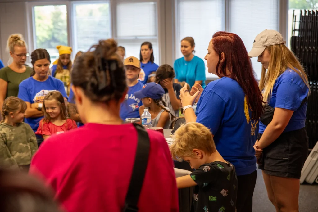 A group of volunteers praying together before VBS