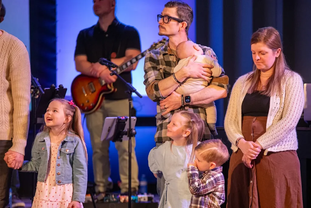 Family dedicating heir children at Redemption