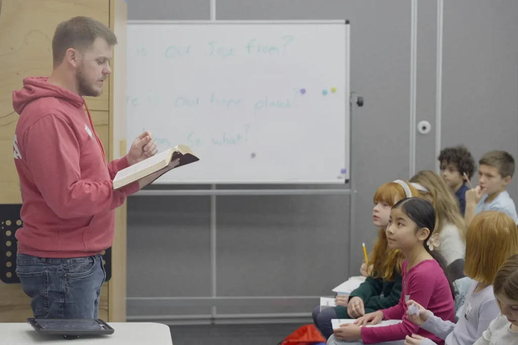 Teacher in front of classroom teaching a Bible story to kids