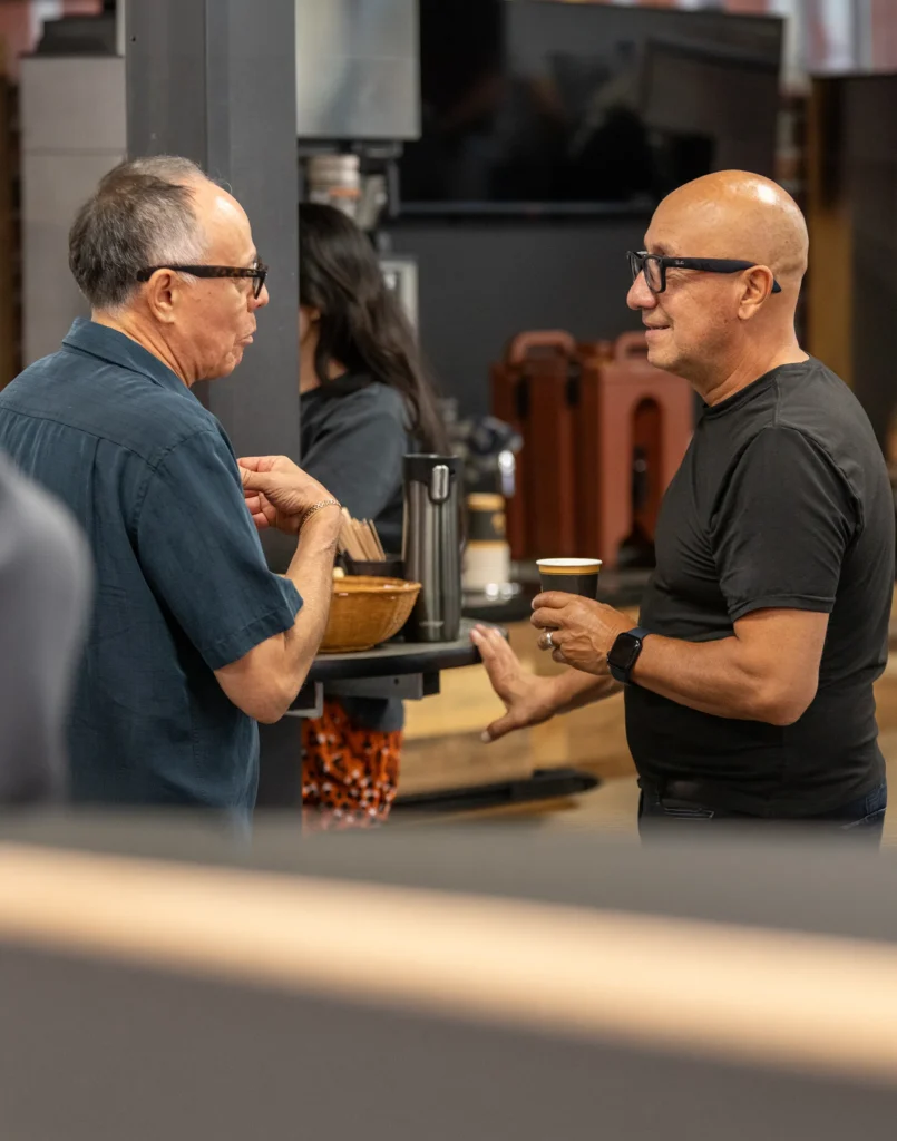 Two members drinking coffee together and chatting after service