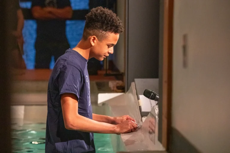 A young man giving testimony in baptism tank