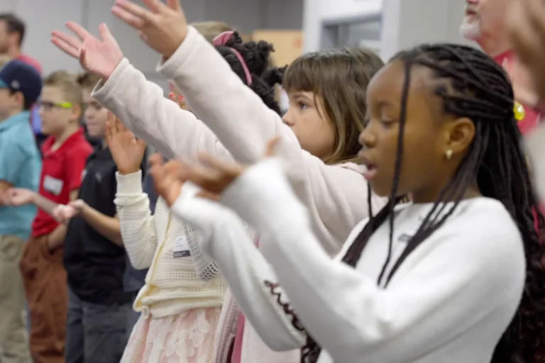 Kids worshipping with arms raised