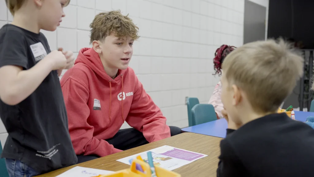 Youth helper talking to children