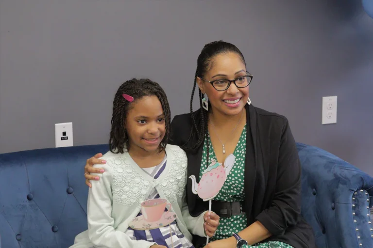 Mother and daughter sitting down on a sofa
