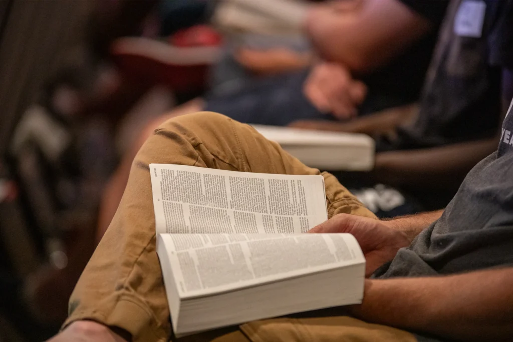 A person with Bible opened and reading on lap