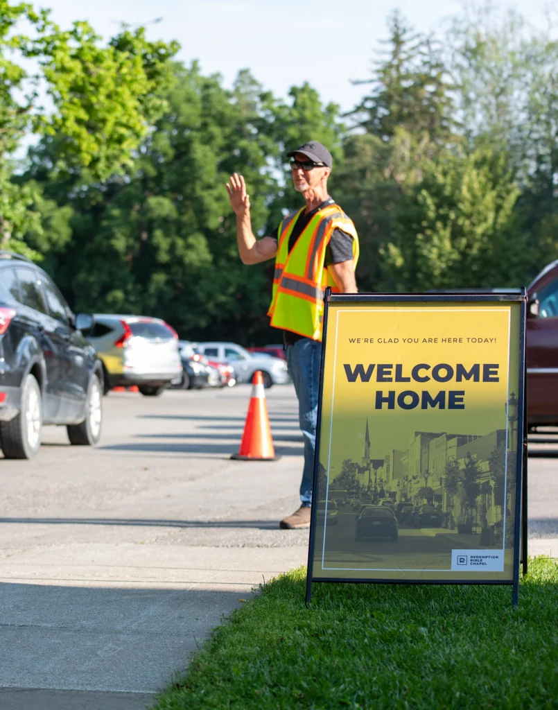 Parking lot team member greeting people as they drive into the church parking lot