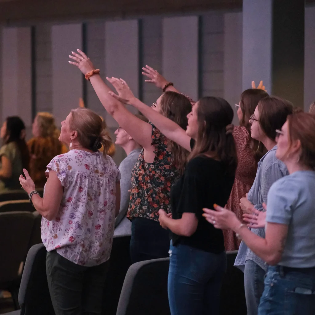 Young people worshipping with arms raised high
