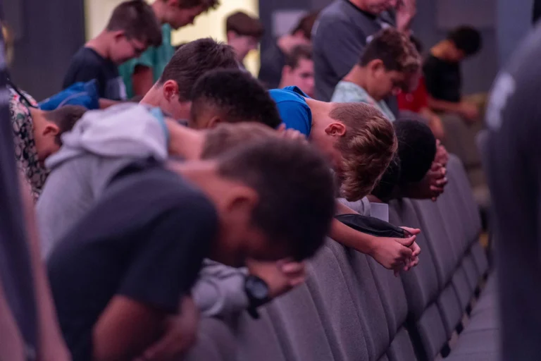 Youth with heads bowed in prayer